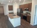 Modern kitchen features granite countertops, a central island, stainless steel appliances, and wood cabinets at 3408 Curlew Ave, Leesburg, FL 34748