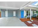 Close-up of a welcoming covered entrance with a bright blue front door and a small seating area at 3520 Sebring Ave, Orlando, FL 32806