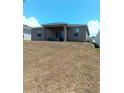 Expansive backyard featuring a covered patio and ample space for outdoor activities and entertainment at 3582 Forster Ave, Leesburg, FL 34748