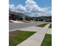 Neighborhood street view with well-manicured lawns, sidewalks, and various home styles at 3582 Forster Ave, Leesburg, FL 34748