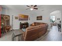 Cozy living room featuring a large leather sofa and modern ceiling fan at 4027 Lakeside Reserve Ct, Orlando, FL 32810
