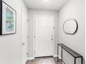 Welcoming foyer featuring a white door, elegant mirror, eye-catching artwork, and stylish flooring at 4215 Swan St, Haines City, FL 33844