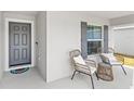Inviting front porch with cozy seating, complemented by a stylish door and window with modern shutters at 4215 Swan St, Haines City, FL 33844