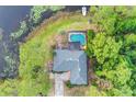 Aerial view of a home with a screened pool and lush surrounding landscape near the water at 516 Fort Smith Blvd, Deltona, FL 32738