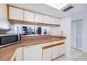 Cozy kitchen featuring granite countertops, white cabinets, and a pass-through to the living area at 530 E Central Blvd # 1702, Orlando, FL 32801