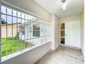 View of front porch with tiled floor, decorative bars, and the home's front door at 5481 Nokomis Cir, Orlando, FL 32839