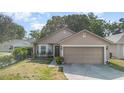 Inviting single-story home with a two-car garage, lush lawn, and a welcoming front entrance at 6701 Belmar Dr, Orlando, FL 32807
