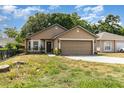 Traditional home with a two-car garage, healthy lawn, and decorative front garden at 6701 Belmar Dr, Orlando, FL 32807