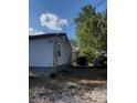 Home exterior showing the home's simple charm with a trailer and vehicle in the ample yard at 7506 Mott Ave, Orlando, FL 32810