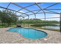 Enjoy a private screened pool with a tranquil waterfall, offering stunning views of the lake and surrounding landscape at 850 Spring Oak Cir, Orlando, FL 32828