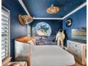 Space-themed bedroom featuring a custom bed, mural, ceiling fan, and decor at 960 Golden Bear Dr, Reunion, FL 34747