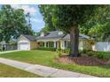 Lovely home with manicured lawn, mature trees, and charming covered porch at 1018 Featherstone Cir, Ocoee, FL 34761
