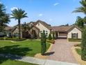 Charming home boasts lush landscaping, a brick driveway, barrel tile roof and a stone-accented façade at 11502 Waterstone Loop Dr, Windermere, FL 34786