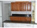 Kitchen features wood cabinets, stone counter tops and breakfast bar, seamlessly connecting to the living spaces at 1518 Indiana St, Orlando, FL 32805