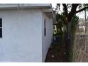 Side exterior view with white stucco, windows, and an A/C unit along the side of the home at 1518 Indiana St, Orlando, FL 32805
