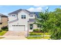 Charming two-story home featuring a brick driveway, well-maintained lawn, and solar panels at 1909 Donahue Dr, Ocoee, FL 34761