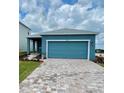 Home exterior featuring blue siding, a brick paver driveway, and a two car garage at 1912 Diamond Head Cir, Lake Hamilton, FL 33851