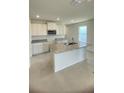 A well-lit kitchen boasts an island sink, white cabinets, granite counters, and modern appliances at 1912 Diamond Head Cir, Lake Hamilton, FL 33851