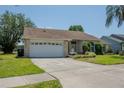 Inviting single-story home with attached two car garage, long driveway, and well-maintained landscaping at 1949 Tiptree Cir, Orlando, FL 32837