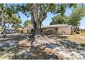 Charming home exterior with mature trees providing shade over the yard at 2007 Peach Tree Blvd, St Cloud, FL 34769