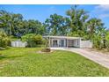 Attractive single-story home with a lush green lawn, complemented by mature trees and tropical landscaping at 2707 E Marks St, Orlando, FL 32803