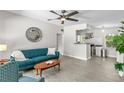 Open-concept living room featuring modern decor and gray wood-look flooring leads into bright, cozy kitchen at 2707 E Marks St, Orlando, FL 32803