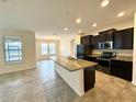 Open-concept kitchen with granite countertops, stainless steel appliances, and an island at 274 Brunswick Dr, Davenport, FL 33837