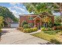 Elegant brick home with a well-manicured lawn and a long driveway leading to a detached garage at 343 Raleigh Pl, Oviedo, FL 32765