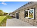 Home's exterior, features stone detail, a well-kept lawn, and ample natural light at 4604 S Shore Rd, Orlando, FL 32839