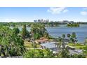 Scenic water view featuring the city skyline, lush trees, and residential homes on the water at 4604 S Shore Rd, Orlando, FL 32839