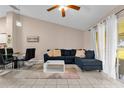 Spacious living room featuring tile flooring, a modern sofa, and natural light at 543 Azinger Cir, Orlando, FL 32824