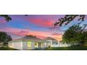 A beautiful backyard view of the home with a colorful sunset in the background at 5839 Tarleton Way, Mount Dora, FL 32757