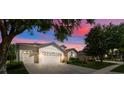 Dusk shot of a lovely home featuring a three-car garage, landscaped yard, and inviting curb appeal at 5839 Tarleton Way, Mount Dora, FL 32757