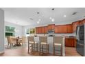 Bright kitchen with wooden cabinets, granite countertops, and a breakfast bar with seating for three at 5839 Tarleton Way, Mount Dora, FL 32757