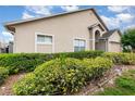 Side view of home shows mulched bed with lush green and yellow hedges at 6019 Long Peak Dr, Orlando, FL 32810
