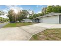 Wide view of the home exterior, driveway, and adjacent lot, capturing the neighborhood setting at 7101 Se 124Th St, Belleview, FL 34420