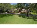 Brick home with lush green lawn, mature trees, and well-maintained landscaping, offering curb appeal at 725 Bear Creek Cir, Winter Springs, FL 32708