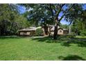 Stately brick home on a large lot, shaded by mature trees, with a well-kept green lawn at 725 Bear Creek Cir, Winter Springs, FL 32708