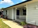 Inviting covered front porch with decorative trim details, and charming curb appeal at 7540 Govern Blvd, Orlando, FL 32822