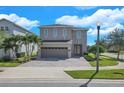 Two story home featuring a neutral color scheme, paved drive and manicured landscaping at 7584 Marker Ave, Kissimmee, FL 34747