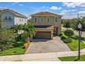 Two story home featuring a neutral color scheme, paved drive and mature trees at 7584 Marker Ave, Kissimmee, FL 34747