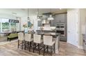 A view of the kitchen island with barstool seating and a dining area bathed in natural light from the nearby window at 861 Junonia Blvd, New Smyrna Beach, FL 32168