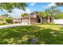 Charming two-story home featuring a large front yard, a two-car garage, and a well-maintained lawn with green grass at 905 N Lake Claire Cir, Oviedo, FL 32765