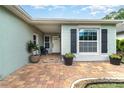 Inviting front porch with brick pavers, potted plants, and a cozy seating area at 1096 Dees Dr, Oviedo, FL 32765