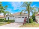 Single-story home showcasing a two-car garage, tiled roof, and a well-manicured front yard at 11878 Via Lucerna Cir, Windermere, FL 34786