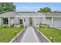 Inviting front entrance with well-maintained landscaping and a decorative pergola at 1218 Fairway Dr, Winter Park, FL 32792