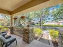 Inviting front porch with stone pillars, comfortable seating, and hanging flower baskets, offering a cozy outdoor space at 12724 Bideford Ave, Windermere, FL 34786