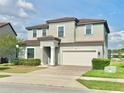 Two-story home featuring neutral paint, attached two-car garage, well-maintained landscaping and a brick driveway at 144 Angelas Ave, Haines City, FL 33844