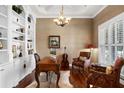 Home office with hardwood floors, built-in shelving, and coffered ceilings at 1448 Conway Isle Cir, Belle Isle, FL 32809