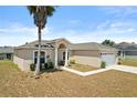 Well-maintained single-story home with a two-car garage, neutral color scheme, and tidy front yard at 15 Sawfish Ln, Kissimmee, FL 34759